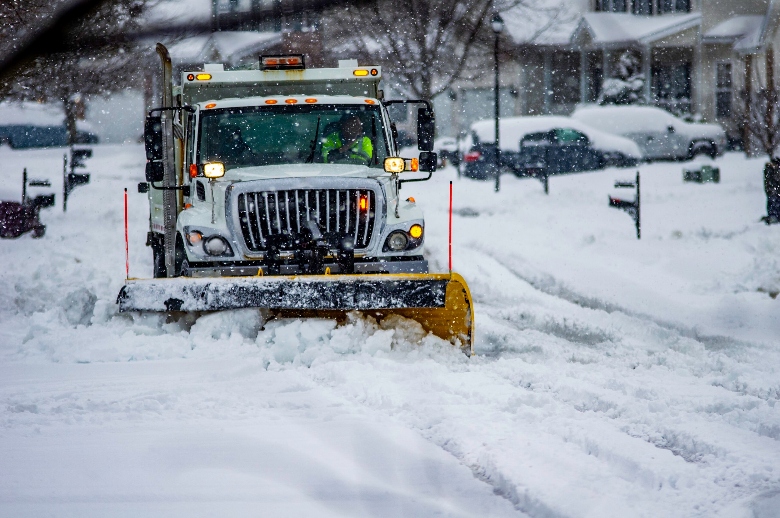 Commercial plow truck clearing snow during an active storm