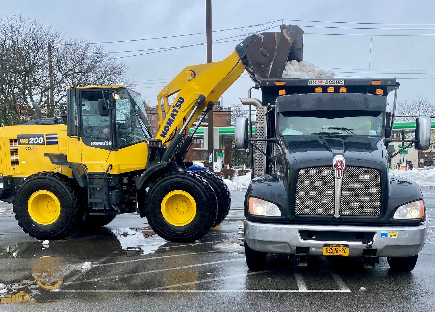 Commercial loader and hauling truck working through event closeout