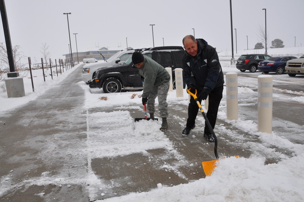 Crew clearing a commercial sidewalk after snowfall